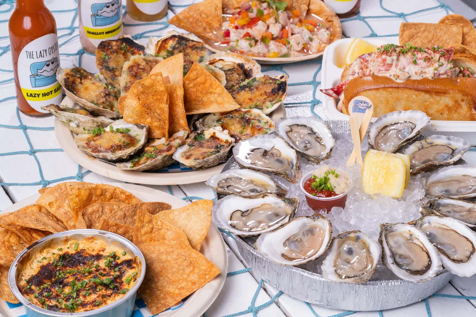 The Lazy Oyster full spread: oysters on ice, chargrilled oysters, lobster roll, and ceviche