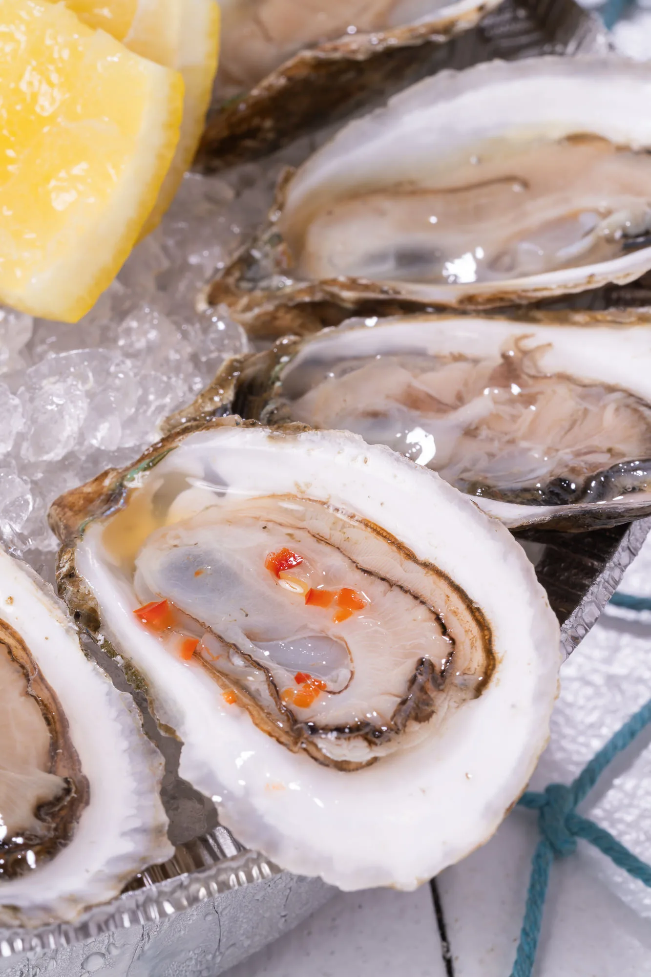 Single fresh oyster on ice with mignonette sauce, shucked to order